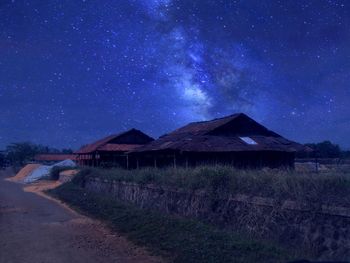 House on field against sky at night