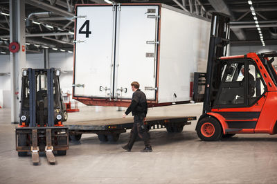 Men driving forklift truck in warehouse in warehouse