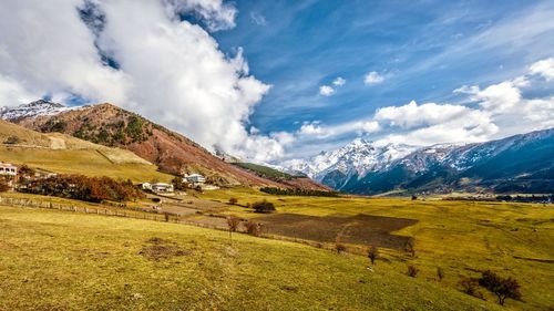 Scenic view of field and mountains against sky