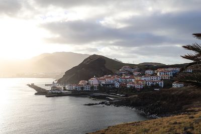 View of townscape by sea against sky