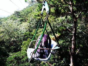 Man sitting on swing at playground