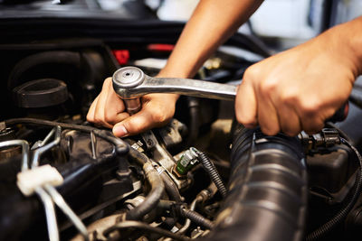 Cropped hand of man repairing car