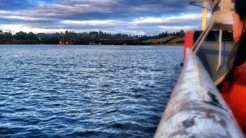 Boats in sea against cloudy sky
