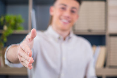 Portrait of young man standing against blurred background