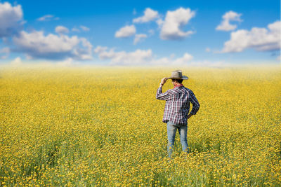 Full length of person standing on field against sky