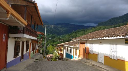 Houses by road against sky in city