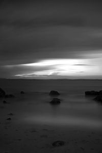 Scenic view of calm sea against cloudy sky