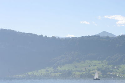 Scenic view of sea and mountains against sky