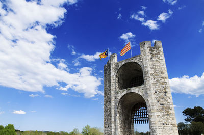 Estelada flag on bridge of besalu against sky