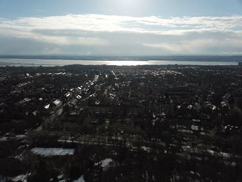 High angle view of townscape by sea against sky