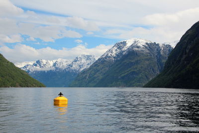 Scenic view of lake by mountain against sky