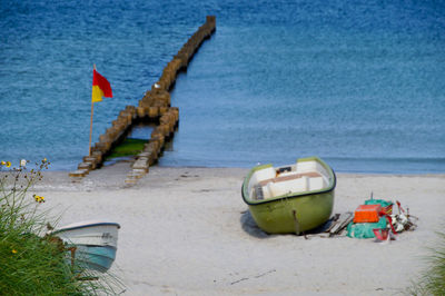 Deck chairs on beach against sky