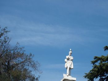 Low angle view of statue against blue sky