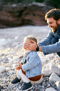 Full length of father and daughter on pebbles