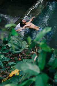 Shirtless man swimming in lake