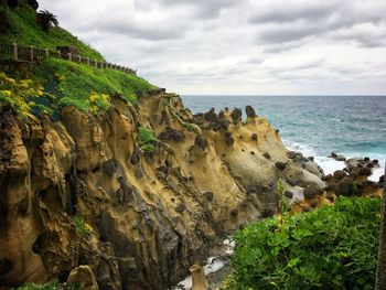 Rock formations by sea against sky