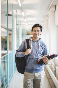 Portrait of smiling male student in corridor of university