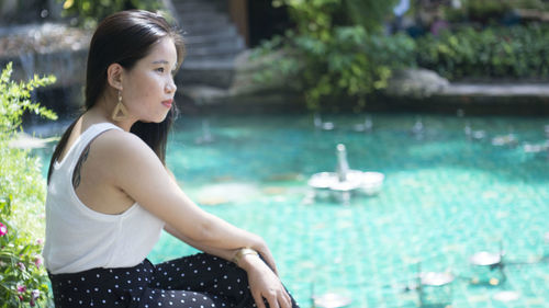 Side view of young woman looking at swimming pool