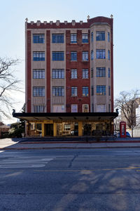 Building by road against blue sky in city