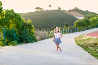 Full length of young woman walking on road