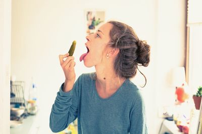 Young woman holding ice cream at home