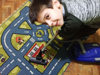 Portrait of boy cleaning carpet with vacuum cleaner