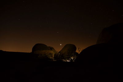 Scenic view of rock formation against sky at night