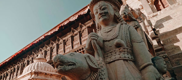 Low angle view of statue against historic building