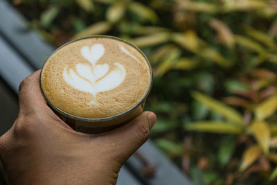 Close-up of hand holding coffee cup