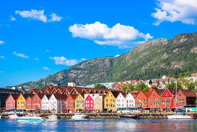 Scenic view of sea by houses and mountains against sky