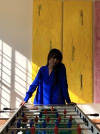 Full length of man playing piano against wall