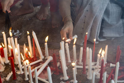 People igniting candles in church