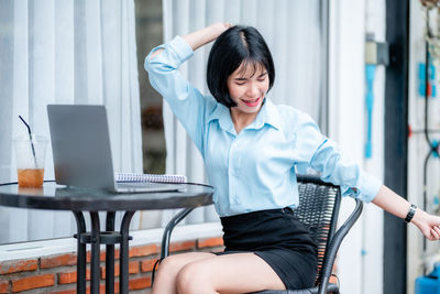 Young woman using laptop while sitting in cafe