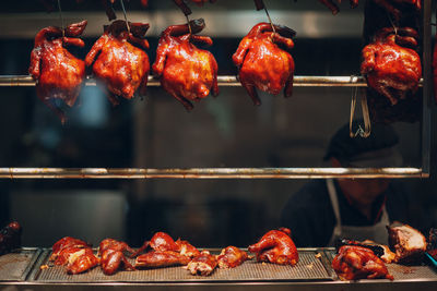 Close-up of roasted chicken hanging on metal rod in restaurant