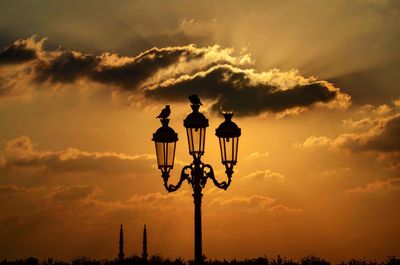 Low angle view of street light against orange sky