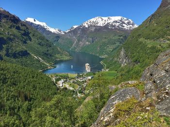 Scenic view of lake and mountains against blue sky