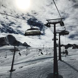 Low angle view of ski lift against sky during winter