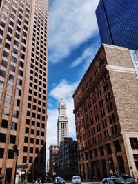 Low angle view of skyscrapers against cloudy sky
