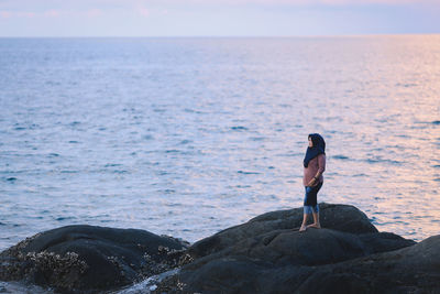 Woman looking at sea against sky