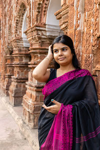 A pretty indian woman in saree near a terracotta temple of west bengal