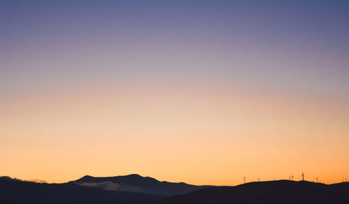 Silhouette mountains against clear sky during sunset