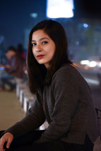 Portrait of smiling young woman sitting outdoors