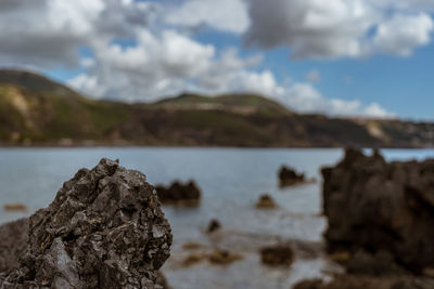 Close-up of rock in sea against sky