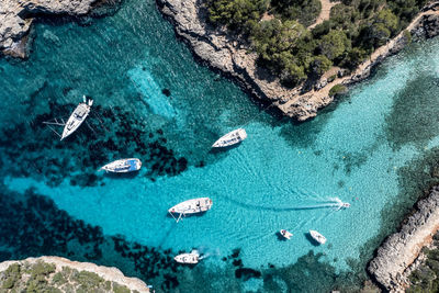 Spain, balearic islands, mallorca, aerial view of boats floating in blue bay of cala sa nau