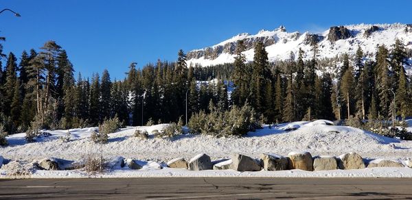 Snow covered landscape against blue sky