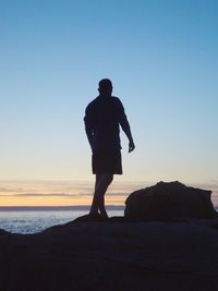 Rear view of silhouette man standing on beach