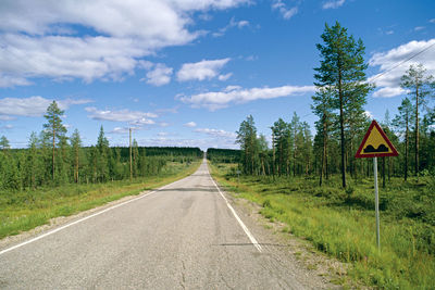 Road amidst green landscape against sky