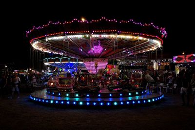Illuminated amusement park ride at night