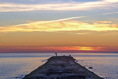 Fishermen enjoying the sunrise and their hobby.