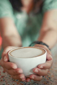 Close-up of hand holding coffee cup